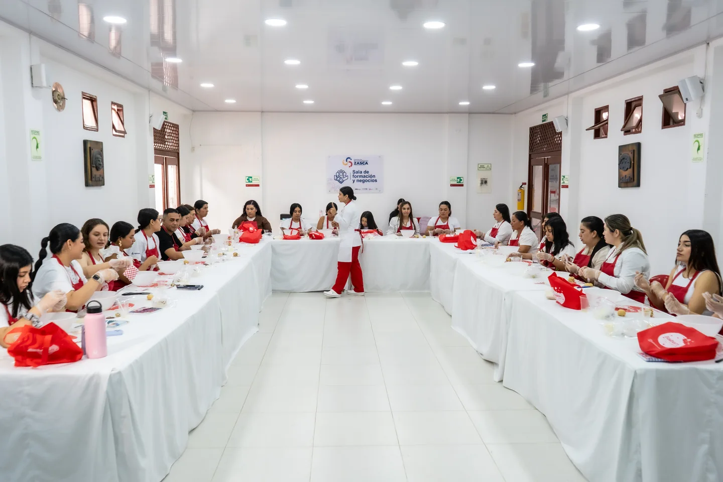 Participantes trabajando alrededor de las mesas del taller.