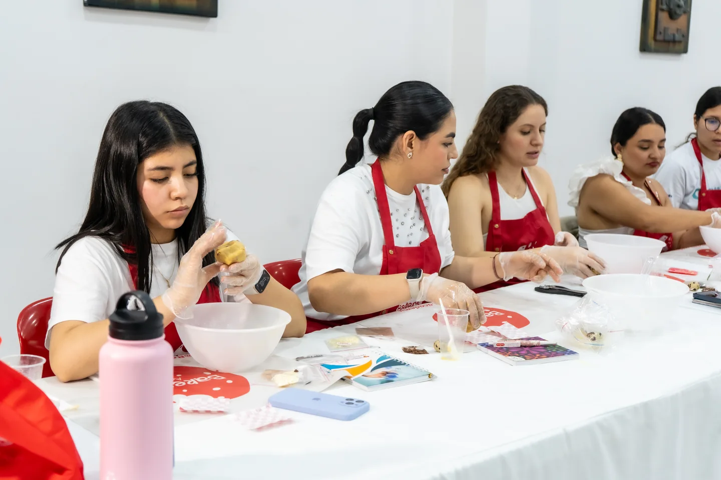 Alumnas formando cookies durante una clase práctica.