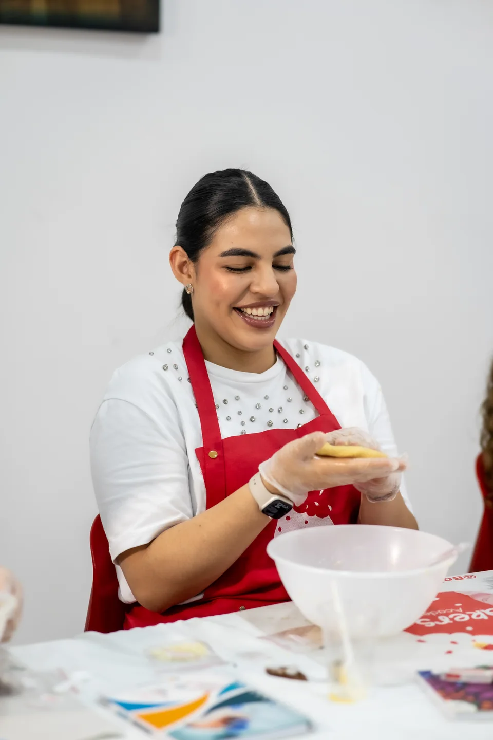 Una participante sonríe mientras prepara su cookie.
